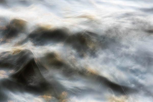 Fine art print of water ripples in blue, black and gold colours.